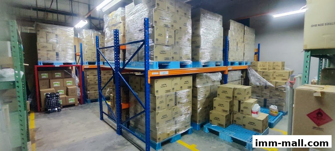 A warehouse interior with shelves stacked high with boxed products, many wrapped in plastic.