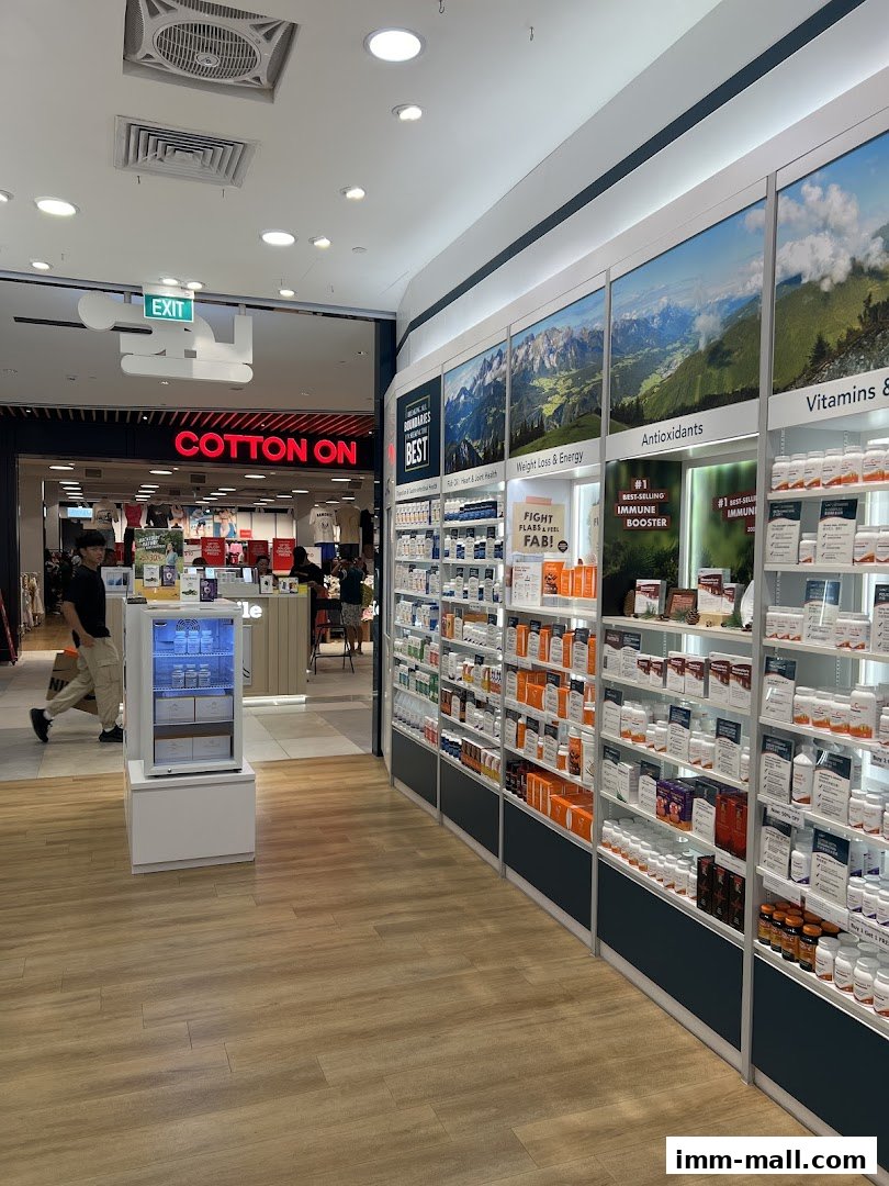 A well-stocked health and wellness store with shelves of supplements and a view of a neighboring clothing store.