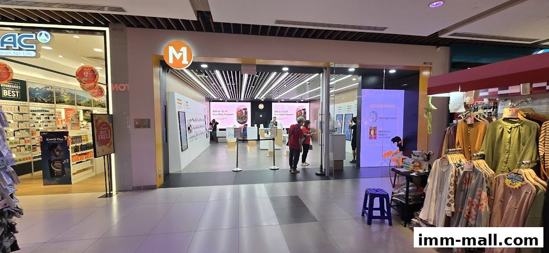 The entrance of an M1 phone shop and internet service provider with displays and staff inside.