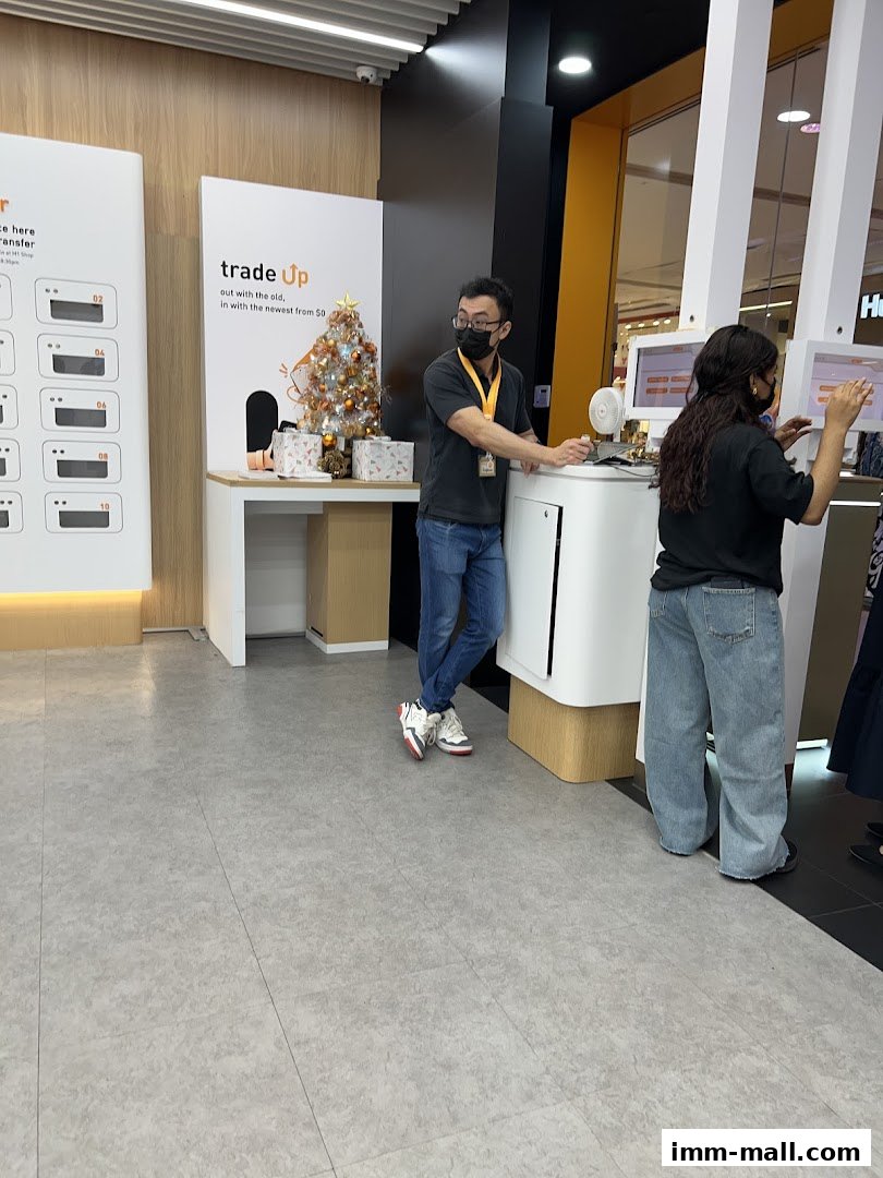 Staff assisting customers at a phone shop with a festive Christmas display.