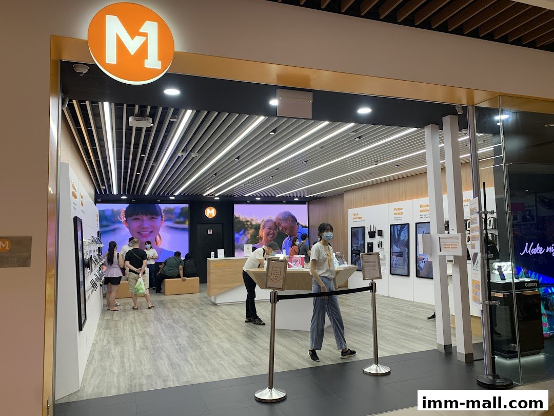 Interior view of an M1 phone shop with customers and displays.