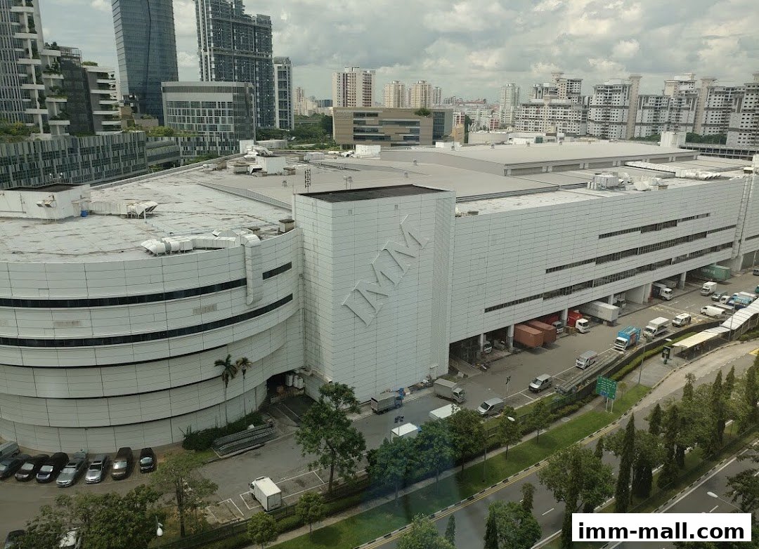 A large, modern industrial building with the logo 'IMM' prominently displayed on its facade.