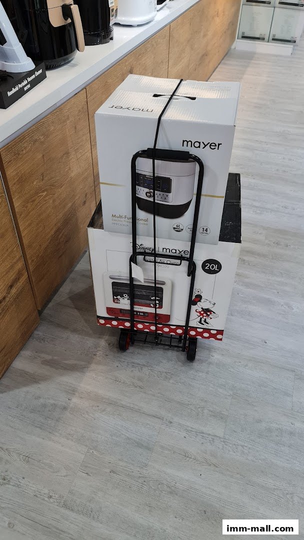 Two Mayer branded boxes, one with a multi-functional electric pressure cooker and another with a Disney air oven, on a trolley.