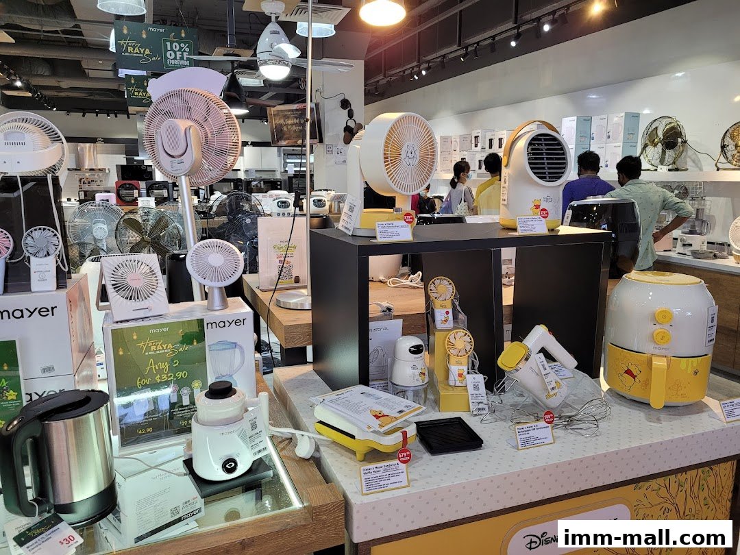 A retail showroom displaying various fans, kitchen appliances, and promotional signage.