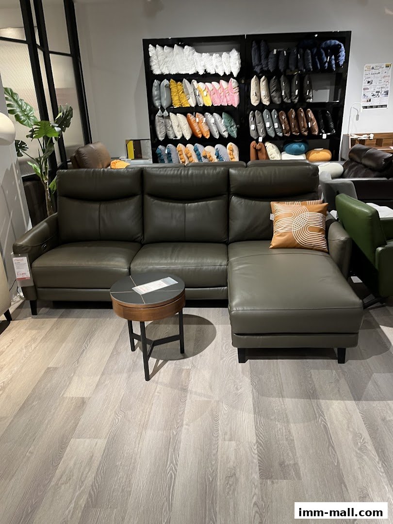 A modern sectional sofa with a stylish accent pillow and a round side table.