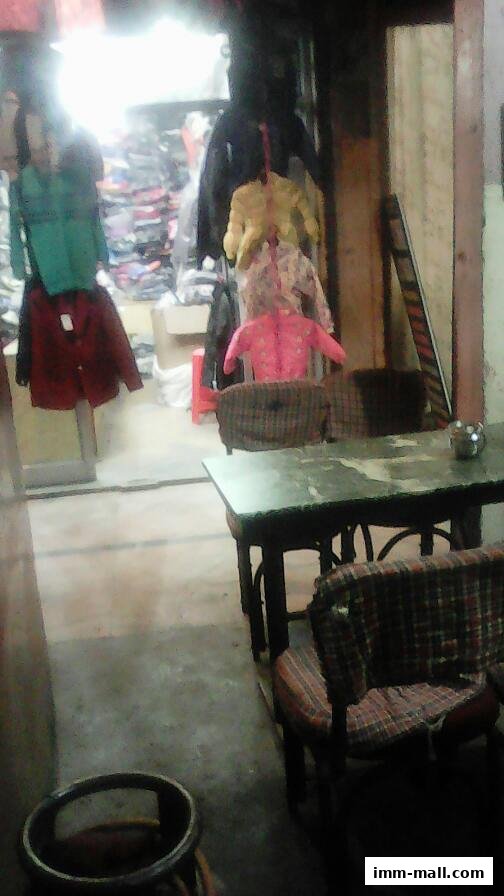 A shop interior with clothes displayed and a table with chairs.
