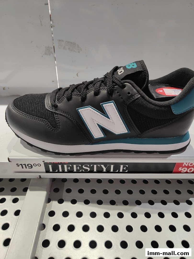 A black New Balance lifestyle sneaker with a white 'N' logo and teal accents is displayed.