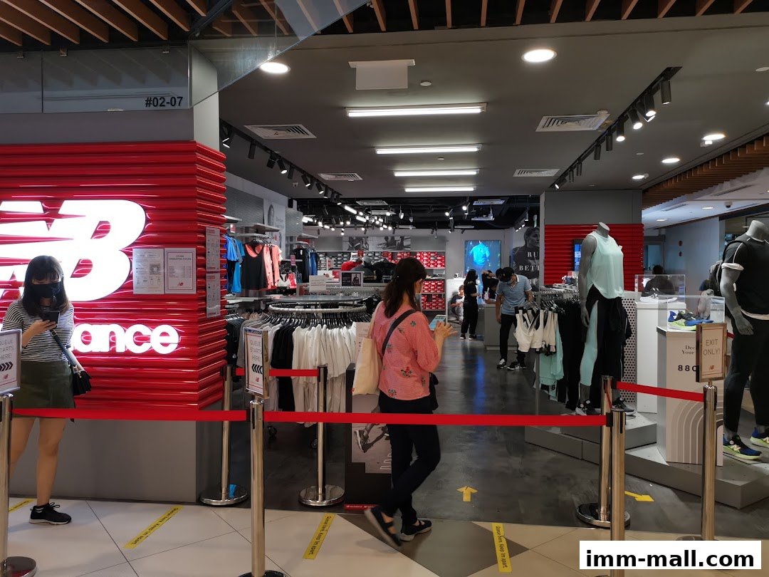 Interior view of a New Balance store with clothing displays and customers.