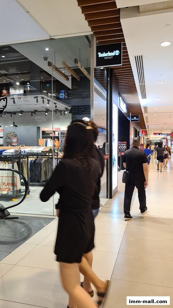 The entrance to a Timberland Outlet store in a shopping mall, with clothing displayed inside.