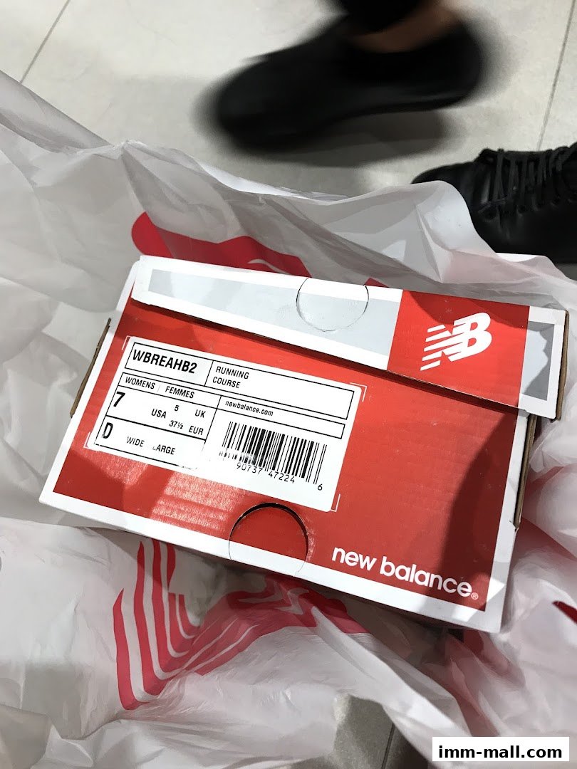 A New Balance shoe box with size information inside a shopping bag.