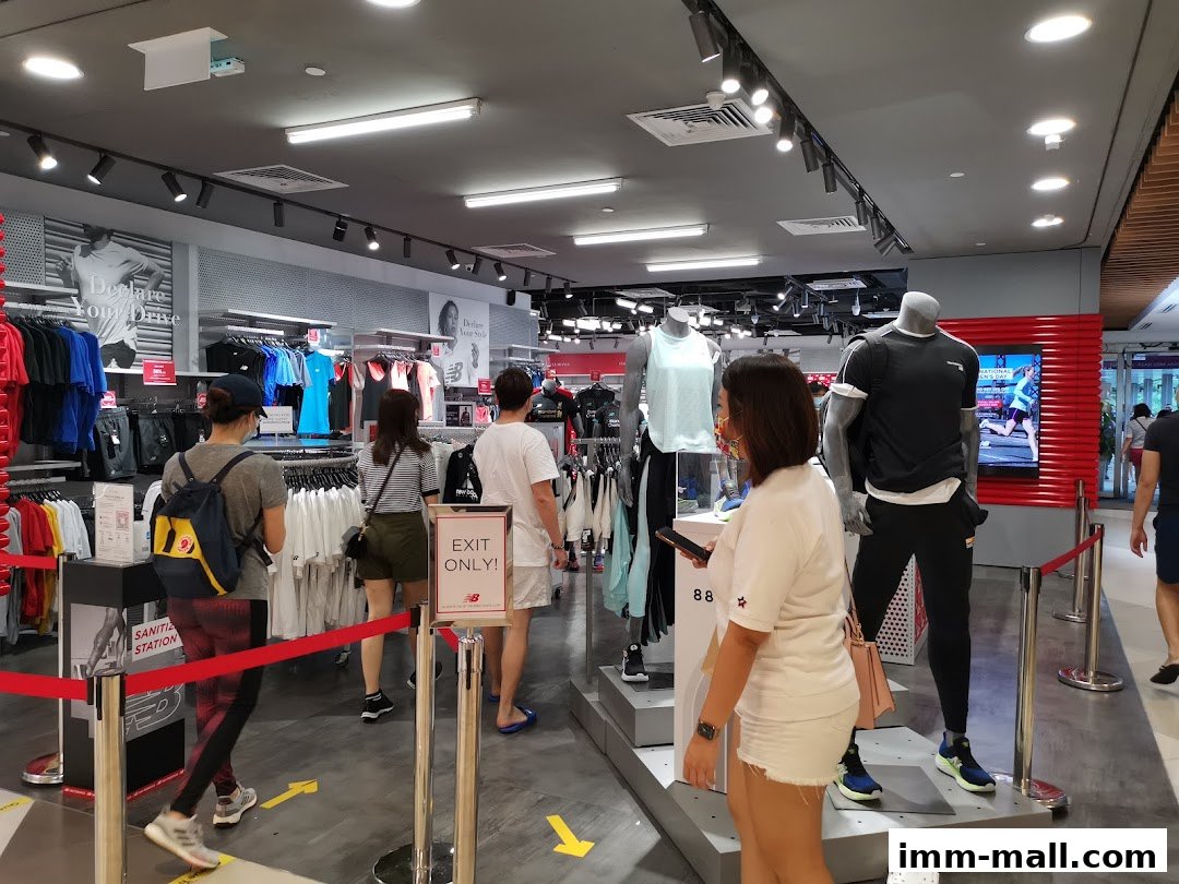 Customers browse athletic wear inside a New Balance store with mannequins displaying outfits.