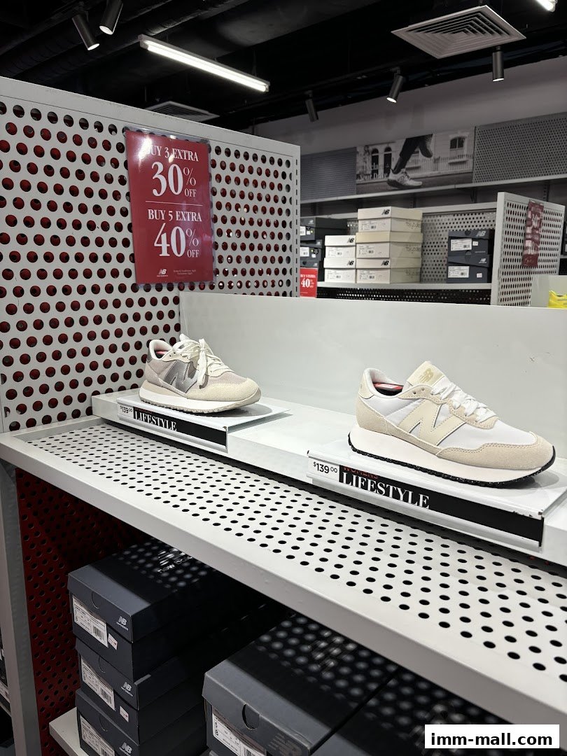 New Balance shoes displayed on shelves with a promotional sign for discounts.