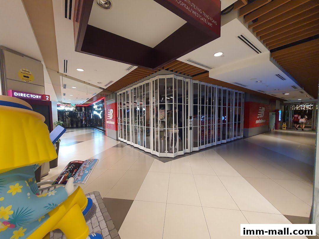 The New Balance Premium Factory Outlet shop front with closed accordion doors and prominent branding.