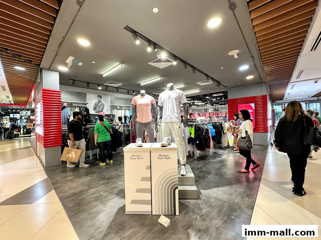 Interior view of a New Balance store with mannequins displaying apparel and racks of clothing.