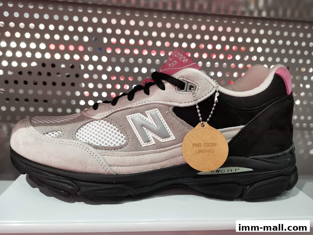 A New Balance sneaker with a pig skin lining tag displayed on a shelf.