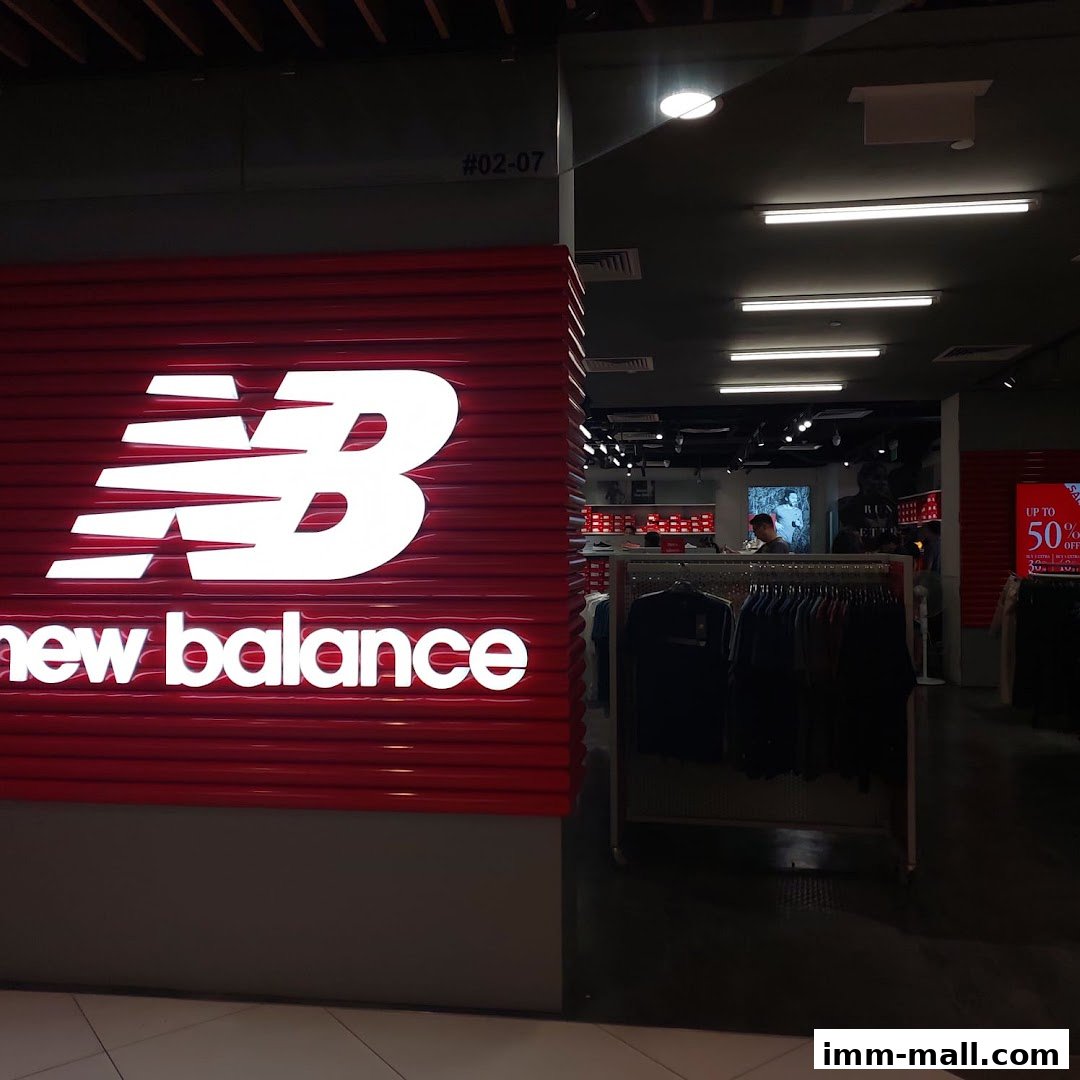 The New Balance Premium Factory Outlet features a prominent red sign with the brand's logo and name.