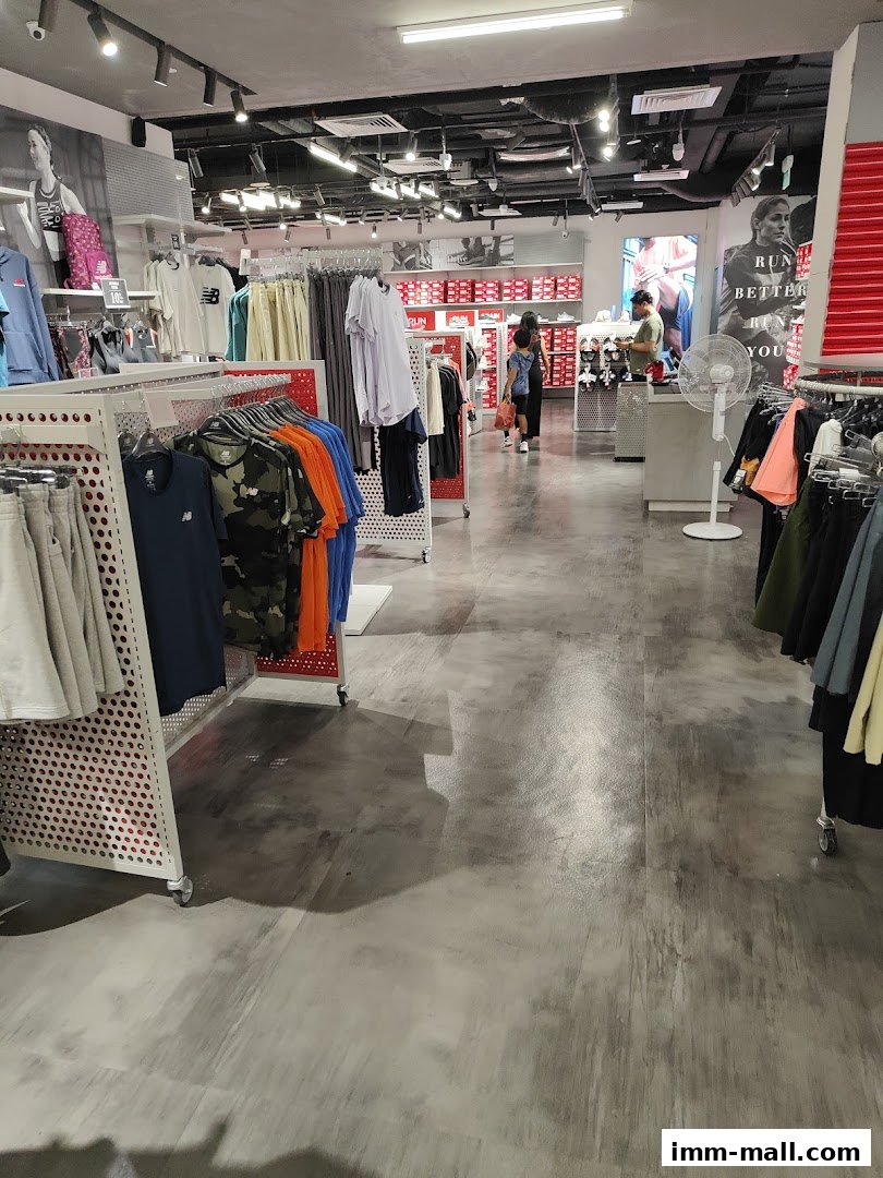 Interior view of a New Balance factory outlet store with apparel and footwear displays.