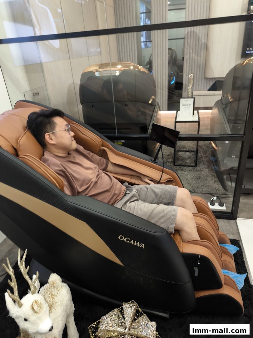 A man relaxes in an OGAWA massage chair, showcasing comfort and advanced features.