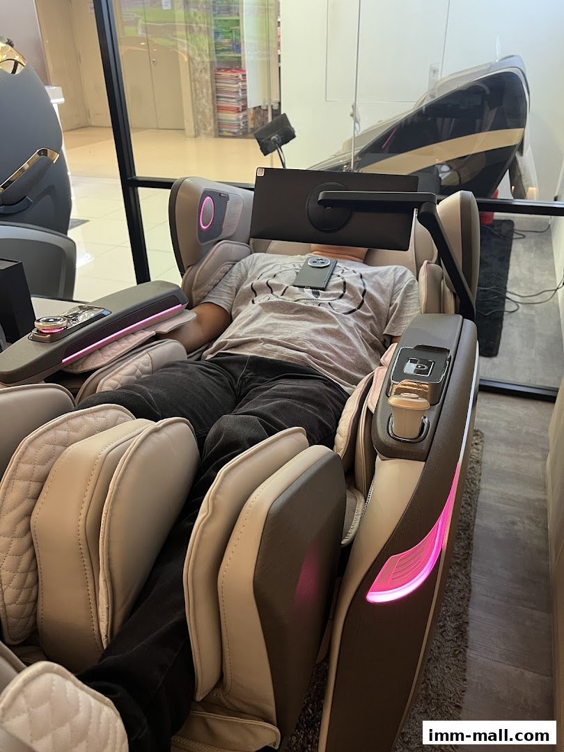 A person relaxing in a high-tech massage chair with a tablet attached.