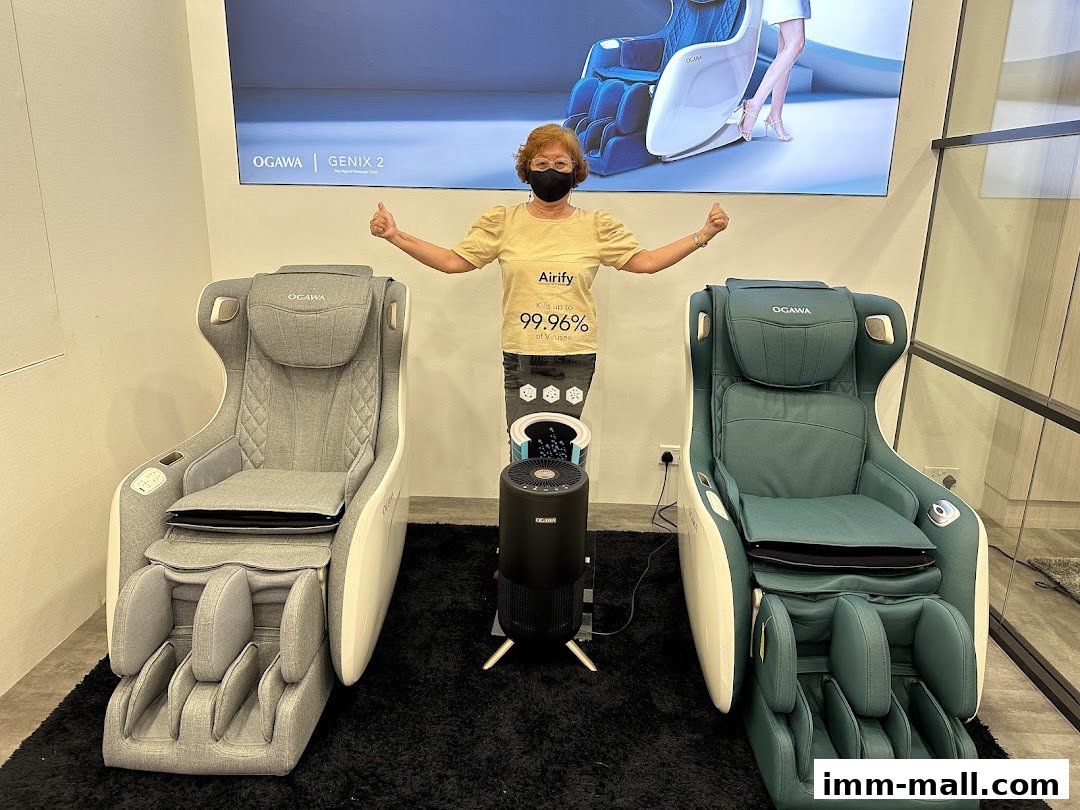 A woman gives a thumbs up next to two OGAWA massage chairs and an air purifier.