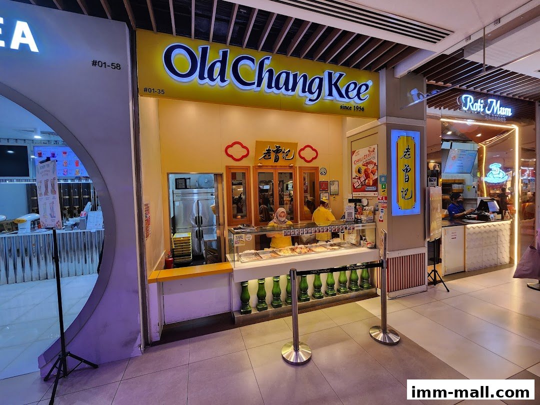 The Old Chang Kee shop front with staff serving customers and displaying food items.