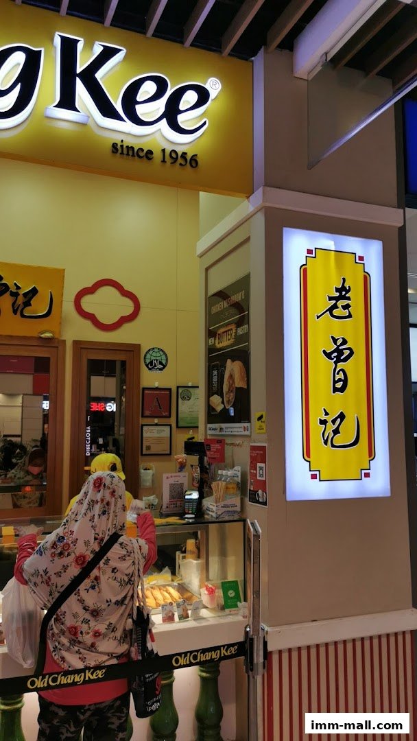 The Old Chang Kee shop front with its iconic signage and a customer being served.
