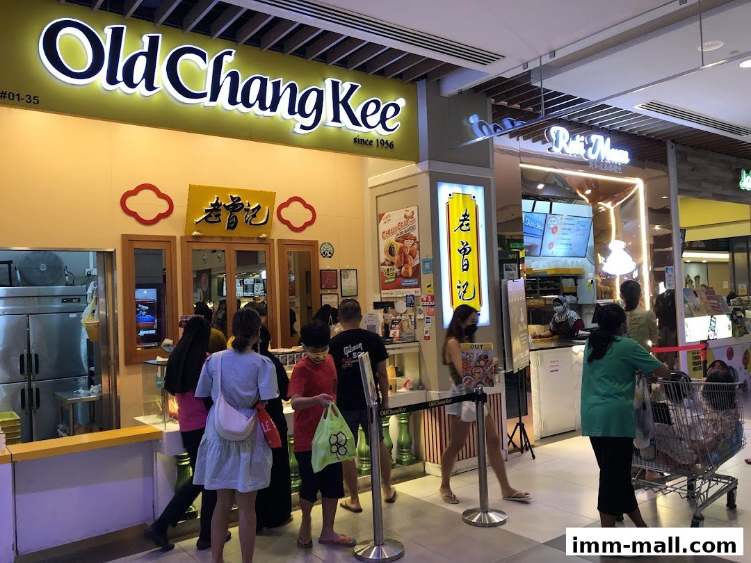 People queuing at the Old Chang Kee shop entrance with its prominent signage.