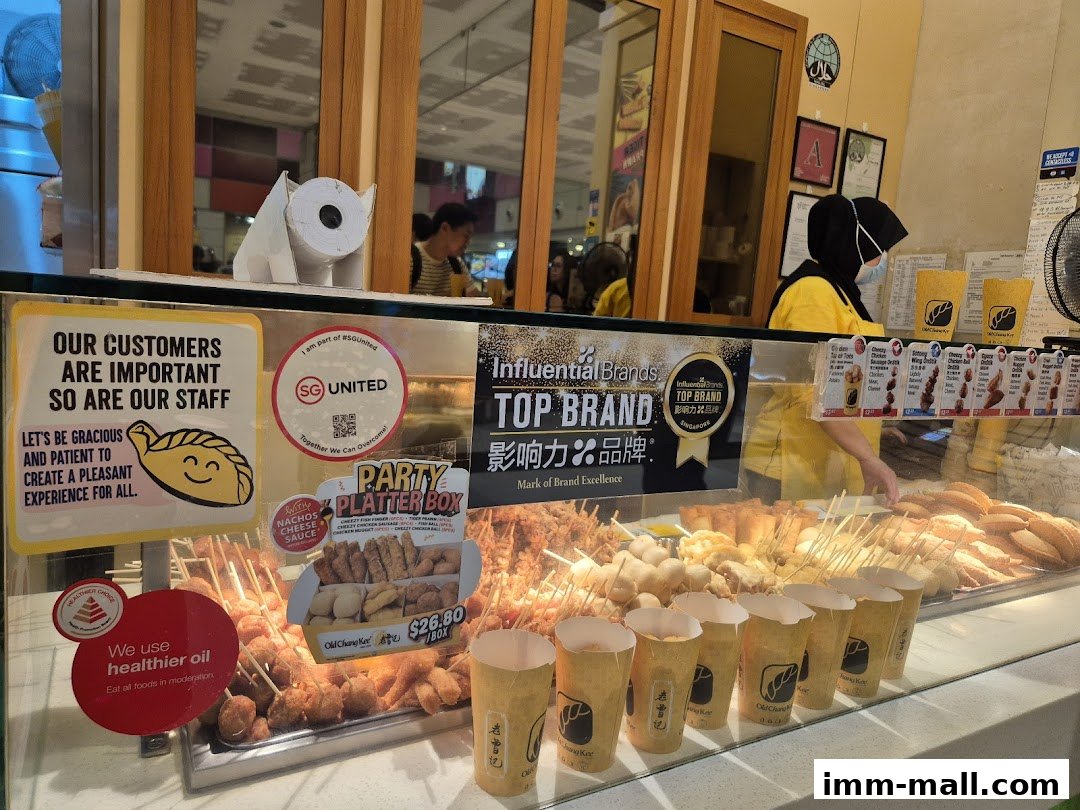 A display counter at Old Chang Kee showcasing various fried snacks and drinks.