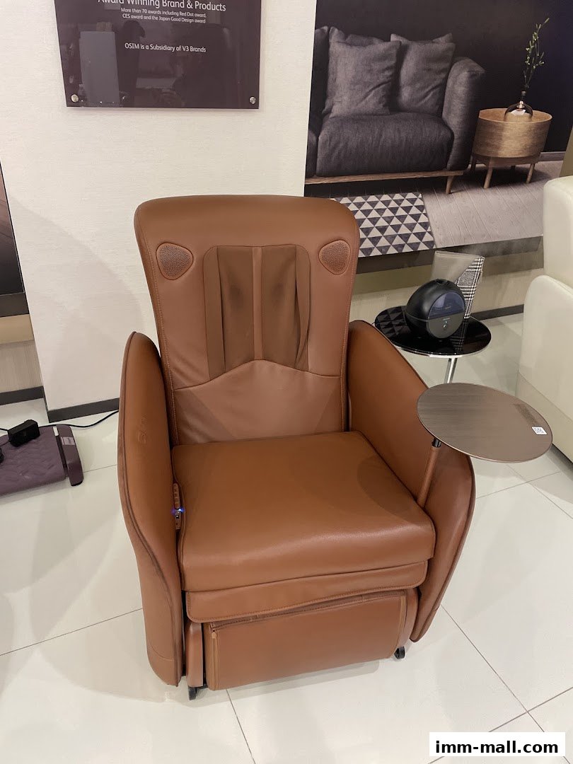 A brown leather massage chair with a side table and a small humidifier.