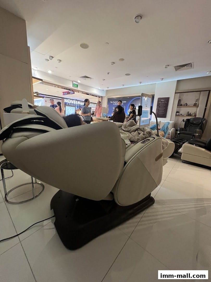 Interior of an OSIM shop showcasing massage chairs and customers.