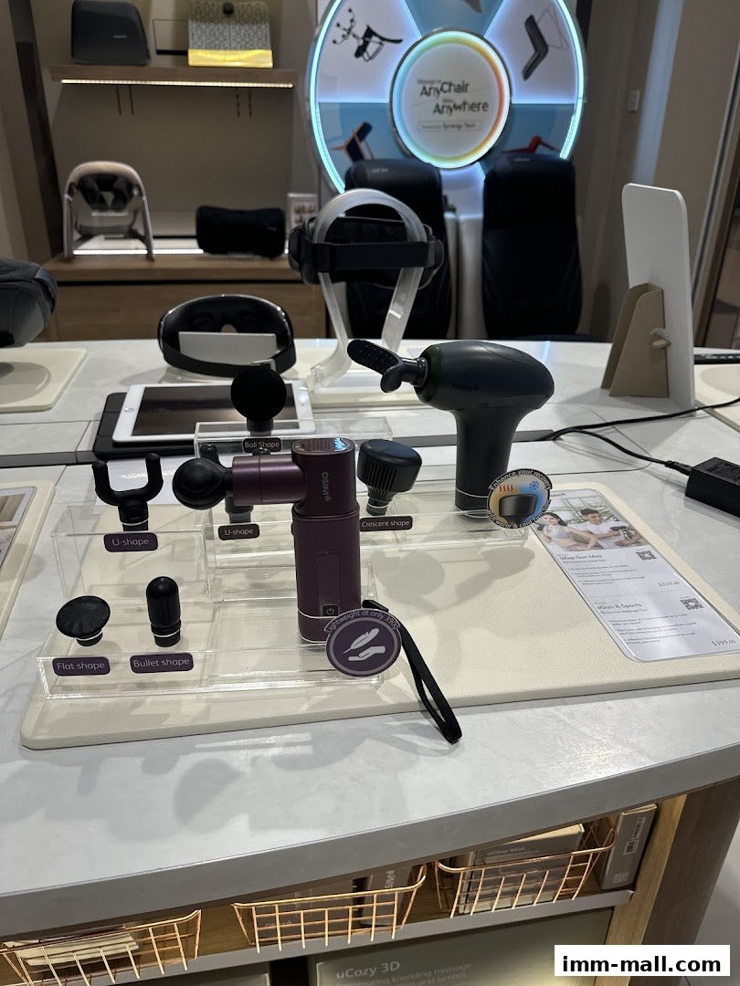 OSIM shop display featuring massage guns and accessories, with chairs in the background.