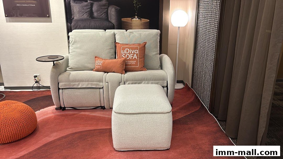 A modern living room setup featuring a light-colored sofa with an ottoman and decorative pillows.