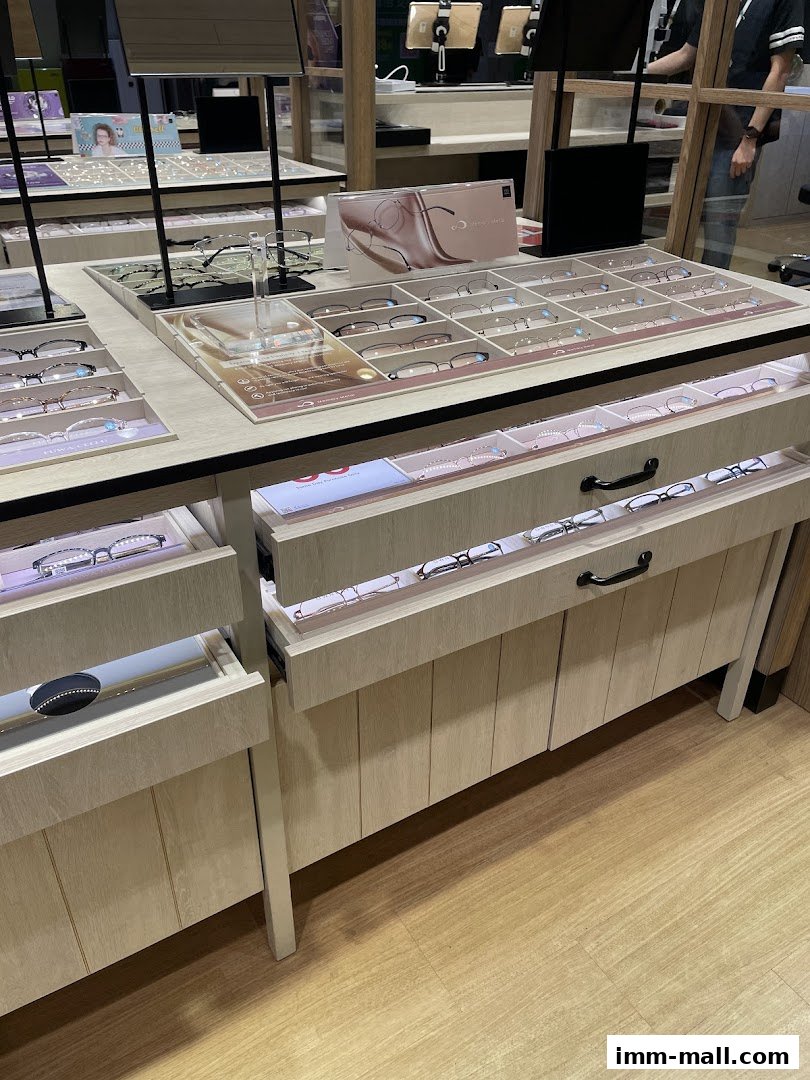 A display of various eyeglasses neatly arranged in drawers and on shelves.
