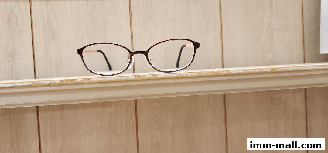 A pair of stylish, thin-rimmed eyeglasses displayed on a shelf.