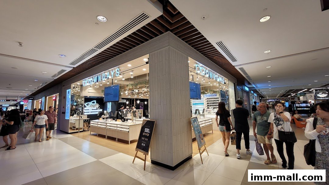 The OWNDAYS IMM outlet shop front with customers browsing inside and outside.
