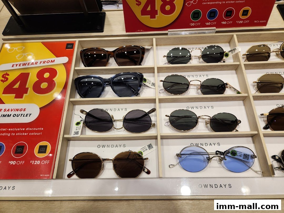 A display of various sunglasses and eyeglasses with a promotional sign for savings.