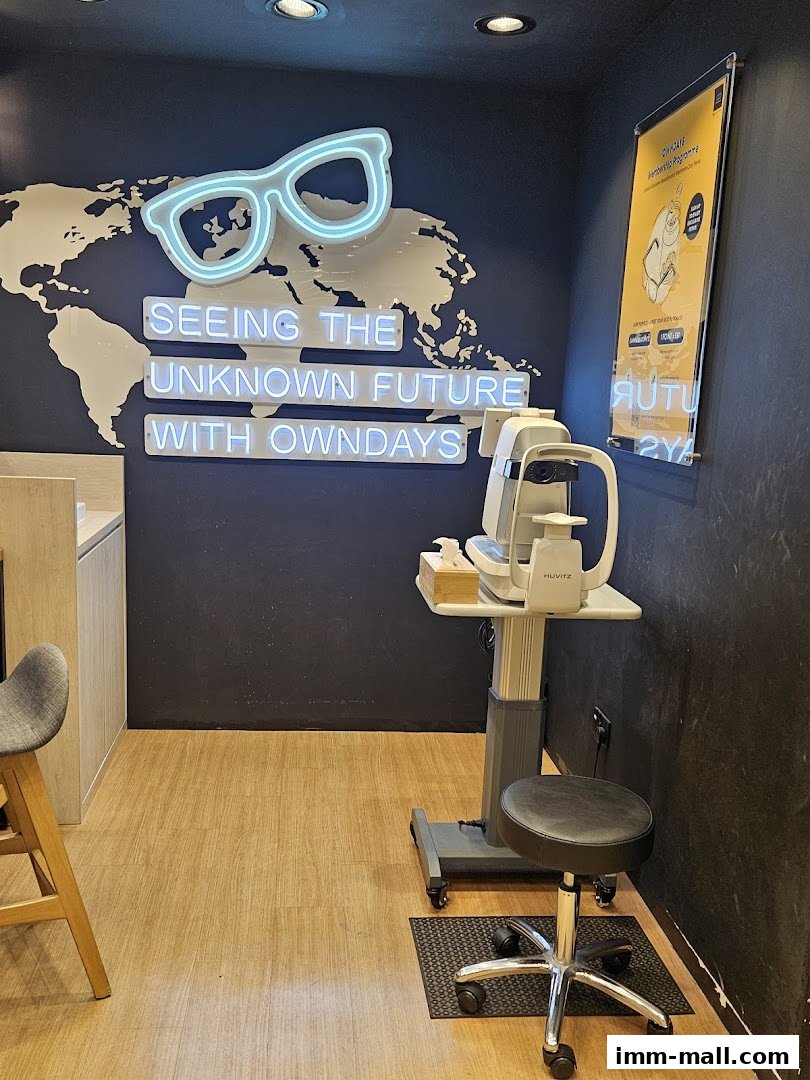 Interior shot of an optical shop with neon glasses sign and eye examination equipment.