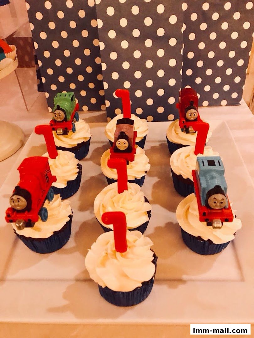 Cupcakes decorated with Thomas the Tank Engine characters and number 1 candles.