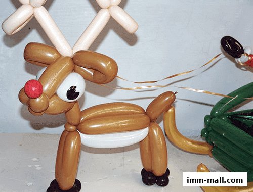 A balloon sculpture of a reindeer pulling a sleigh with Santa.