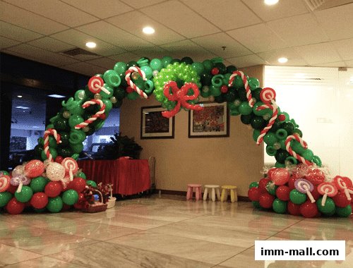 A festive balloon arch decorated with candy canes and lollipops, perfect for events.