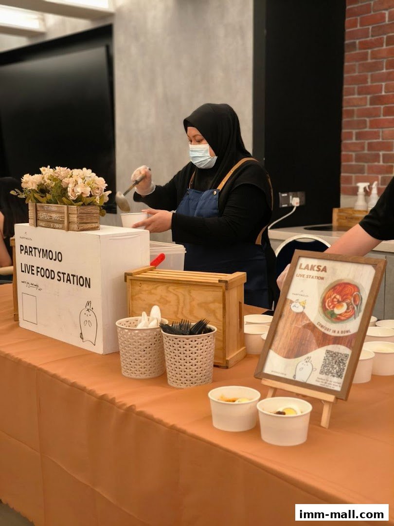 A person serving food at a Partymojo live food station.