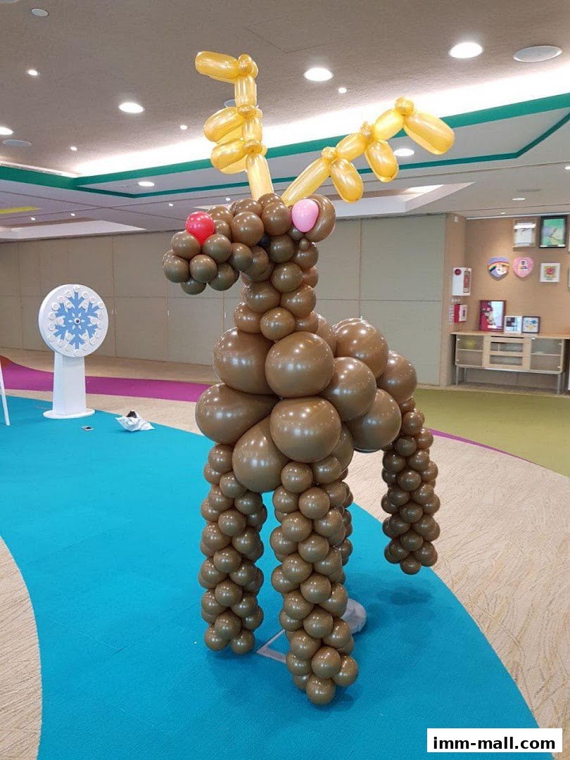 A large balloon sculpture of a reindeer with golden antlers and a red nose.
