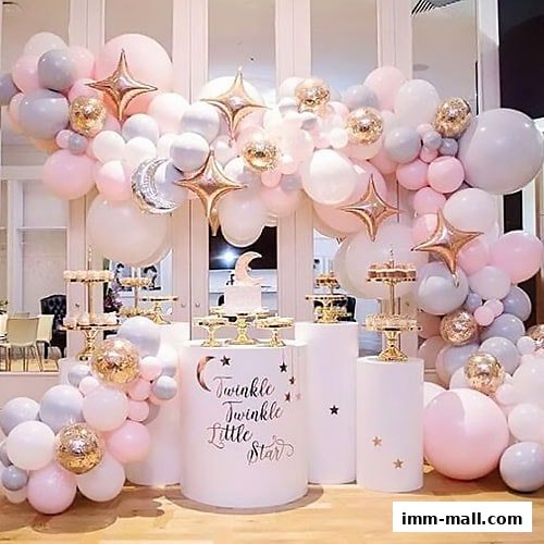 A beautifully decorated party setup with a balloon arch, cake, and themed display.