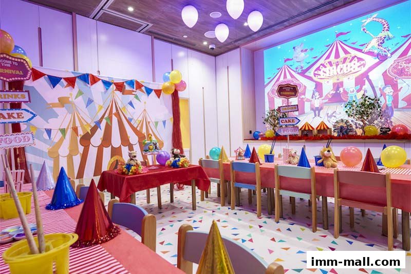 A festive party room decorated with a circus theme, featuring colorful balloons, banners, and a table setting.