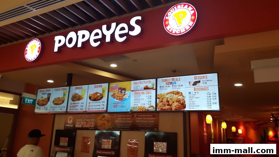 A brightly lit Popeyes restaurant menu board displaying various chicken meals, seafood, burgers, and drinks.
