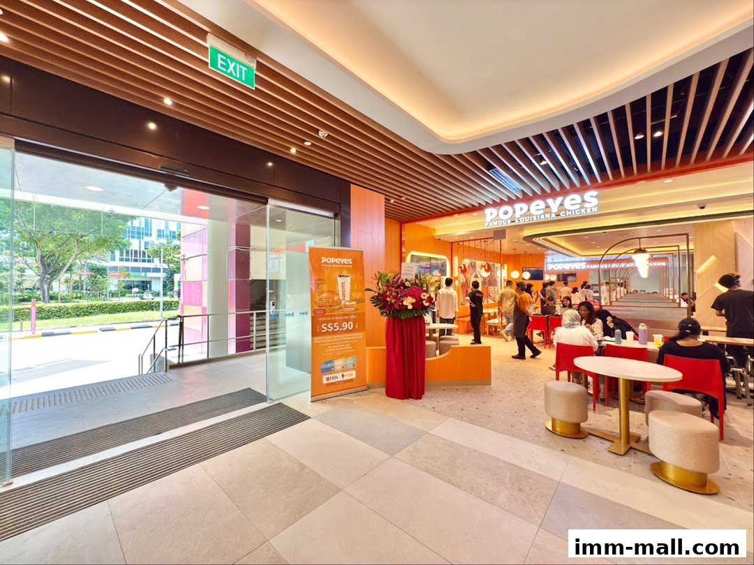 The entrance and interior of a Popeyes restaurant with customers dining.
