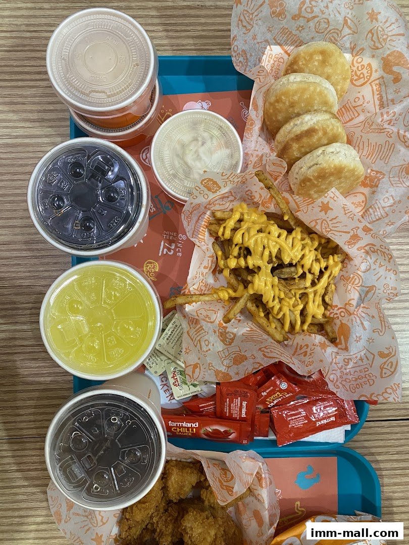 A tray of Popeyes food including chicken, biscuits, fries, drinks, and sauces.