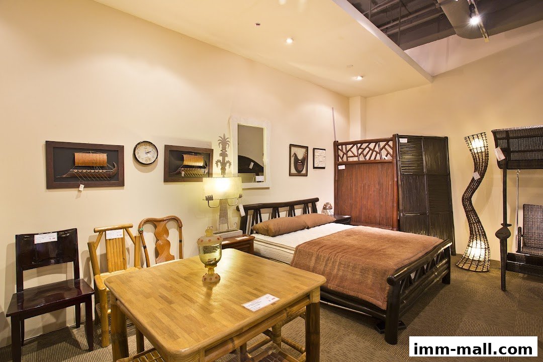 A bedroom display featuring a rattan bed, chairs, a table, and decorative items.