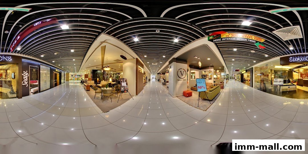 A panoramic view of a modern shopping mall interior with various retail stores and displays.