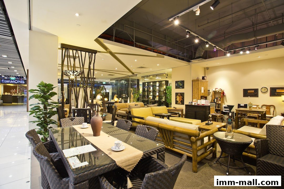 Interior view of a furniture store showcasing rattan and wooden furniture, including dining sets and sofas.